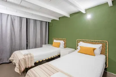 two beds in a room with green walls at The Collection Barcelona - Modern and bright 4BD triplex in Paralel! in Barcelona
