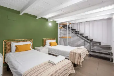 two beds in a room with a staircase at The Collection Barcelona - Modern and bright 4BD triplex in Paralel! in Barcelona