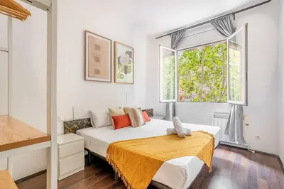 a bedroom with a large bed and a window at The Collection Barcelona - 4- Bedroom Apartment in Gracia Village in Barcelona