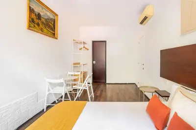 a room with a bed and a table and chairs at The Collection Barcelona - 4- Bedroom Apartment in Gracia Village in Barcelona
