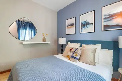 a bedroom with a blue and white bed and a mirror at The Collection Barcelona - City View Penthouse - 2 Bedroom Suite in Barcelona