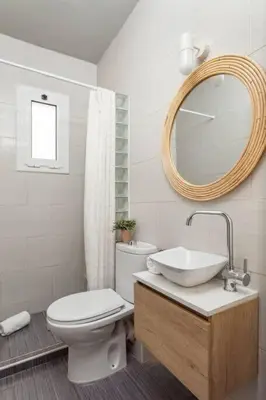 a bathroom with a toilet and a sink and a mirror at The Collection Barcelona - City View Penthouse - 2 Bedroom Suite in Barcelona