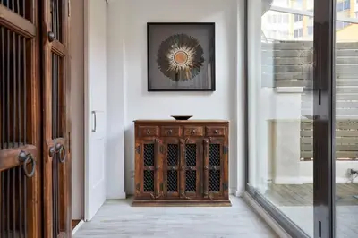 a hallway with a wooden cabinet and a mirror on the wall at The Collection Barcelona - Classy 3BD - 2BTH with private patio in Eixample in Barcelona