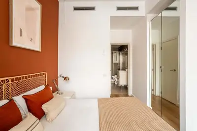 a bedroom with a bed with orange walls and a mirror at The Collection Barcelona - Gorgeous 4bed 4bath close to City Center in Barcelona