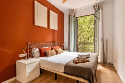a bedroom with a bed with orange walls and a window at The Collection Barcelona - Perfectly located 4bed 4bath apartment in Eixample in Barcelona