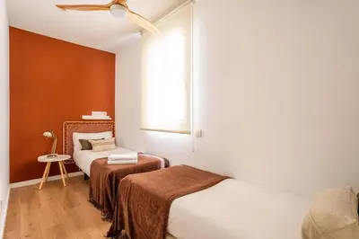 a small bedroom with two beds and a window at The Collection Barcelona - Perfectly located 4bed 4bath apartment in Eixample in Barcelona