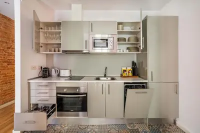 a small kitchen with white cabinets and a sink at The Collection Barcelona - Perfectly located 4bed 4bath apartment in Eixample in Barcelona