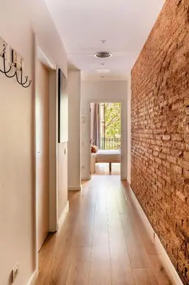 a hallway with a brick wall and a hallway with a chair at The Collection Barcelona - Paseo de Gracia spacious 4BD - 4BTH in Barcelona