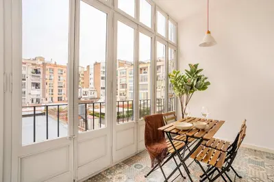 a dining room with a table and chairs and windows at The Collection Barcelona - Paseo de Gracia spacious 4BD - 4BTH in Barcelona