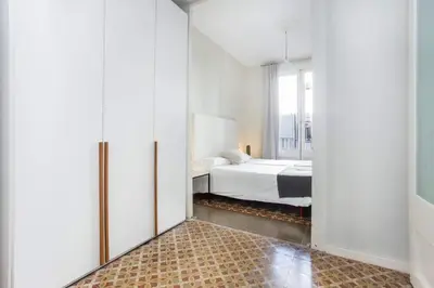 a white bedroom with a bed and a window at The Collection Barcelona - 4bedroom apart with balcony in Las Ramblas 1 1 in Barcelona