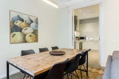 a dining room table with chairs and a painting of pears at The Collection Barcelona - 4bedroom apart with balcony in Las Ramblas 1 1 in Barcelona
