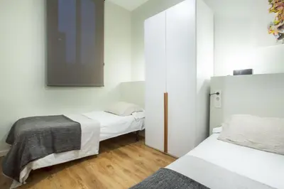 a kitchen with a stainless steel refrigerator and a table at The Collection Barcelona - 4bedroom apartment with a balcony in Las Ramblas 1 2 in Barcelona
