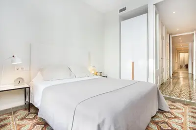 a bedroom with a large white bed and a window at The Collection Barcelona - 4 bedroom apartment with a balcony in Las Ramblas 2 2 in Barcelona
