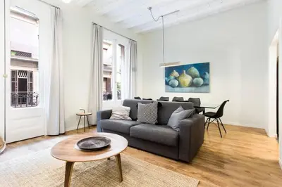 a kitchen with a stainless steel refrigerator and a table at The Collection Barcelona - Bright and modern 4bedroom with terrace in Las Ramblas P2 in Barcelona