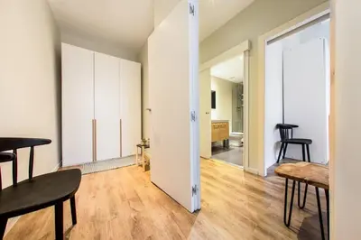 two beds in a room with white walls and wooden floors at The Collection Barcelona - Bright and modern 4bedroom with terrace in Las Ramblas P2 in Barcelona