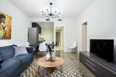 a living room with a blue couch and a table at The Collection Barcelona - Bright and modern 3bedroom in Las Ramblas 3 1B in Barcelona