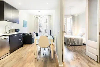 a kitchen and living room with a table and a bed at The Collection Barcelona - Bright and modern 2bedroom in Las Ramblas 2 1A in Barcelona