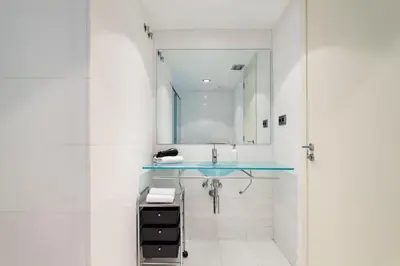a white room with white cabinets and a bed at The Collection Barcelona - Plaça Catalunya Modern 2bedroom with balcony in Barcelona