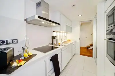 a white kitchen with a sink and a stove at The Collection Barcelona - Luxury Duplex Apartment in the Heart of Barcelona in Barcelona