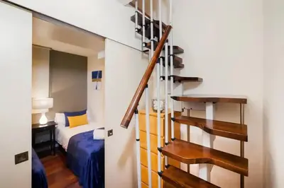 a staircase in a room with a bed and a bedroom at The Collection Barcelona - Luxury Duplex Apartment in the Heart of Barcelona in Barcelona