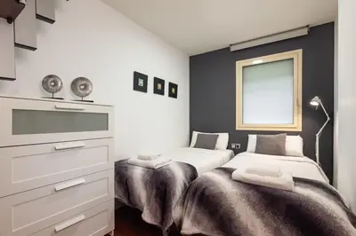 a white bedroom with a bed and white cabinets at The Collection Barcelona - Plaça Catalunya 3bedroom Duplex with Balcony in Barcelona