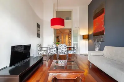 a bedroom with a large white bed and wooden floors at The Collection Barcelona - 3bedroom Duplex with balcony in plaza Cataluña in Barcelona