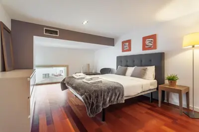 a bedroom with a large bed and a desk at The Collection Barcelona - 3bedroom Duplex with balcony in plaza Cataluña in Barcelona