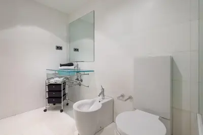 a quotationatory logo with a magnifying glass at The Collection Barcelona - 3bedroom Duplex with balcony in plaza Cataluña in Barcelona