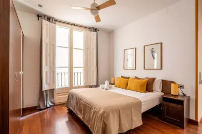 a bedroom with a bed and a large window at The Collection Barcelona - Plaza Urquinaona 3-Bedroom Suite in Barcelona