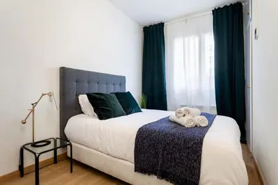 a bedroom with a large bed and a blue chair at The Collection Barcelona - Exclusive Huge 4 Double Bedroom City Center in Barcelona