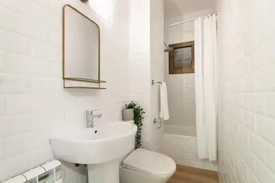 a living room with a chair and a painting on the wall at The Collection Barcelona - Exclusive Huge 4 Double Bedroom City Center in Barcelona