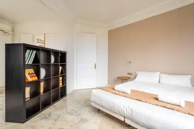 a bedroom with a large bed and a book shelf at The Collection Barcelona - Placa Catalunya Luminous and Exclusive 5Bd Penthouse in Barcelona