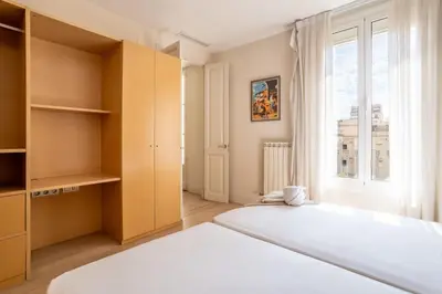 a bedroom with a large bed and a window at The Collection Barcelona - Classy 3bed 3bath apartment in Eixample in Barcelona