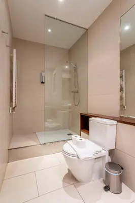 a bathroom with a toilet and a glass shower at The Collection Barcelona - Classy 3bed 3bath apartment in Eixample in Barcelona
