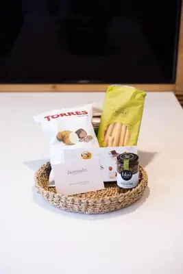 a basket of food and drinks on a table at Apartamento ático en el casco antiguo in Mataró