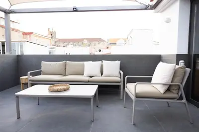 a room with two couches and a table and a coffee table at Apartamento ático en el casco antiguo in Mataró