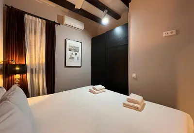 a bedroom with a white bed with two towels on it at Stay U-nique Apartments Est in Barcelona