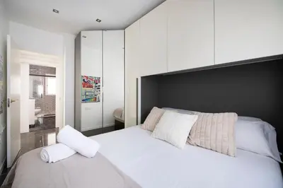 a bedroom with a large white bed with white pillows at PLAYA a 3 minutos Parking barbacoa Apartamento en Castelldefels in Castelldefels