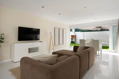 a living room with a couch and a tv at PLAYA a 3 minutos Parking barbacoa Apartamento en Castelldefels in Castelldefels