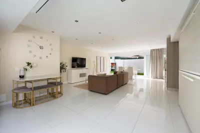 a living room with a couch and a clock on the wall at PLAYA a 3 minutos Parking barbacoa Apartamento en Castelldefels in Castelldefels