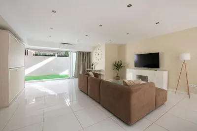 a living room with a couch and a flat screen tv at PLAYA a 3 minutos Parking barbacoa Apartamento en Castelldefels in Castelldefels
