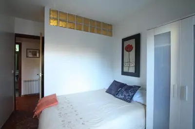 a bedroom with a white bed with blue pillows at GOOD APARTMENTS gran via 3 bedrooms in Barcelona