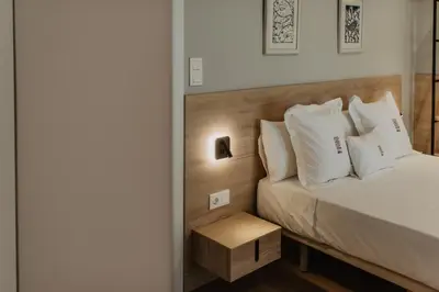 a bedroom with a bed with white pillows at Petit Luxe Volta Apartaments in Terrassa