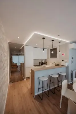 a kitchen and dining room with a counter and stools at Petit Luxe Volta Apartaments in Terrassa