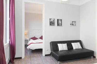 a living room with a black couch and a bed at Whatching Sagrada Familia in Barcelona