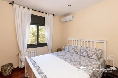 a bedroom with a white bed and a window at Spacious Villa Santa Fe - private pool, big garden and A/C close to Sitges in Olivella