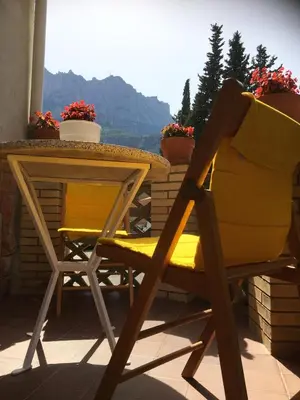 a yellow chair and a table on a balcony at Casa iaia in Monistrol