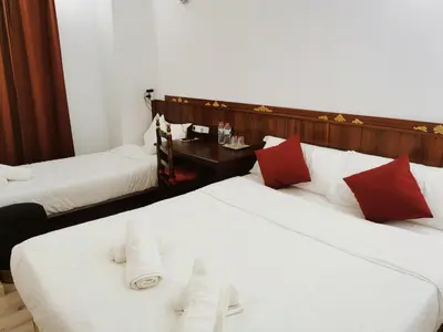 two beds in a hotel room with white and red pillows at Barcelona CoronaHostal in Badalona