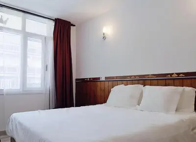 a bedroom with a large white bed with a window at Barcelona CoronaHostal in Badalona