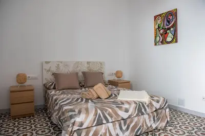 a bedroom with a bed and a painting on the wall at Hauzify I Apartament Can Missé in Calella